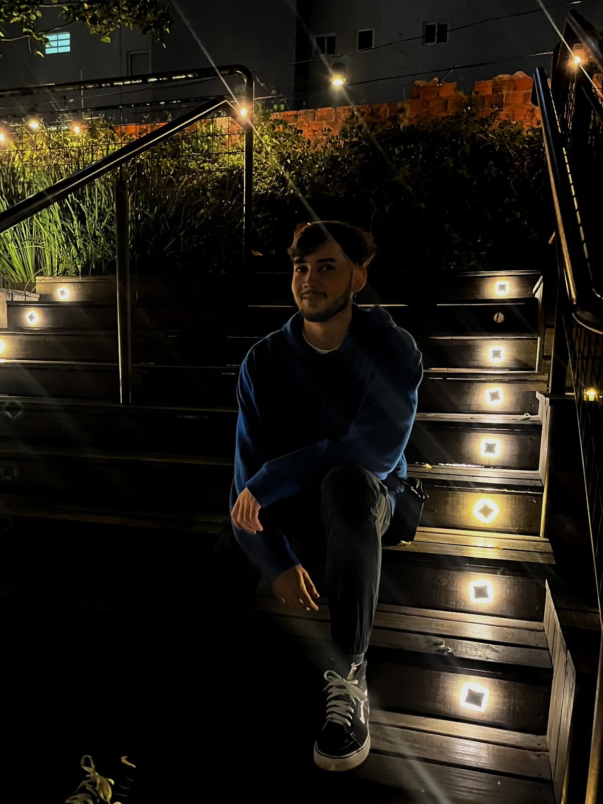Yunguer sitting on lit stairs at night