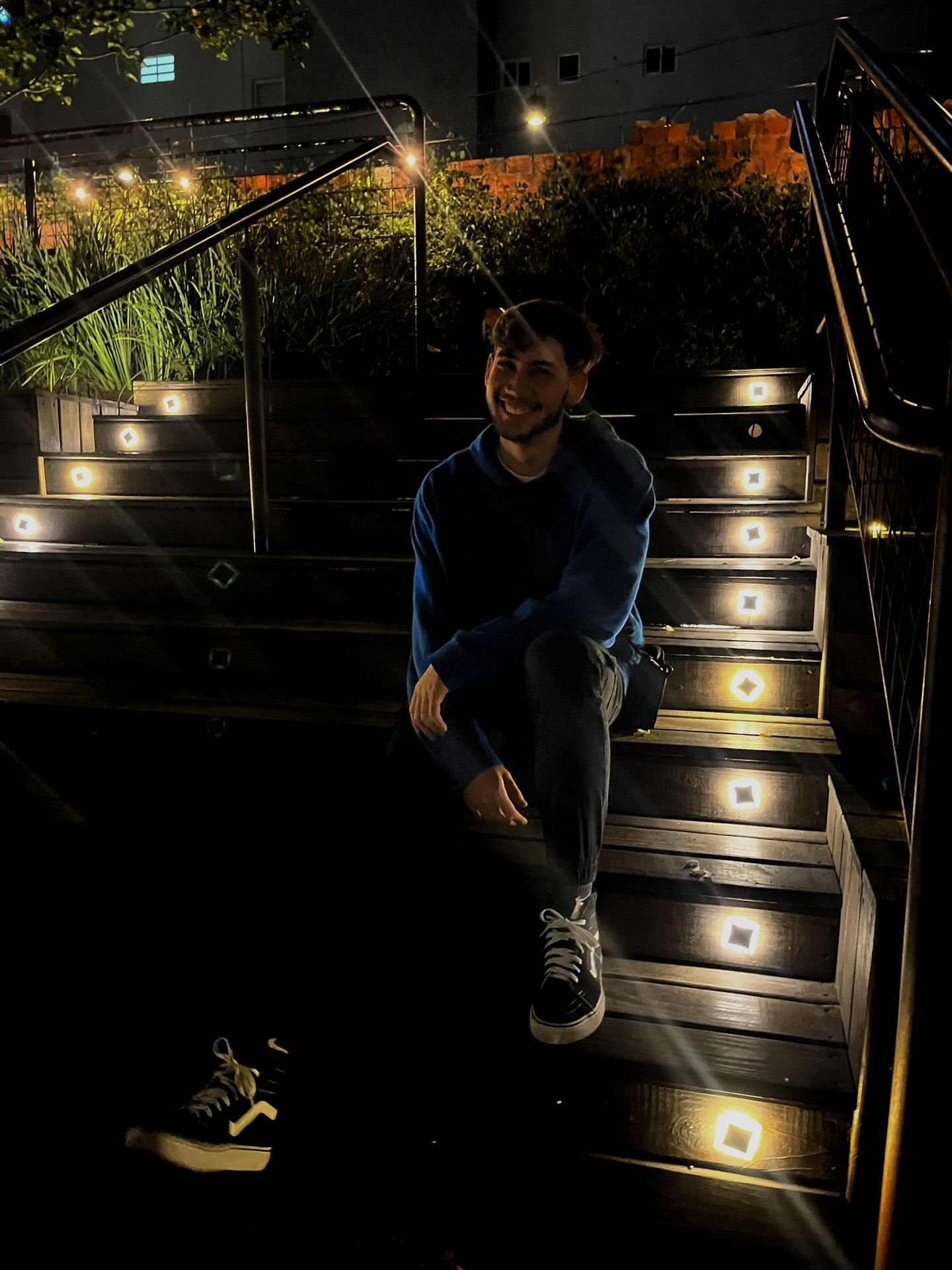 Yunguer sitting on lit stairs at night